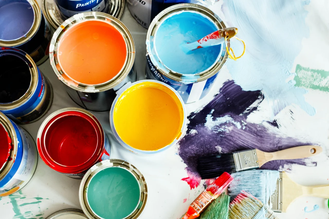 Open paint cans and brush strokes used in Modesto painting projects